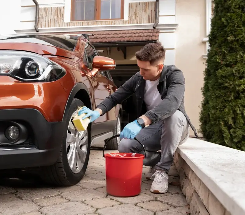 Lavage auto à domicile Les Baux-de-Breteuil : professionnel intervenant sur un véhicule